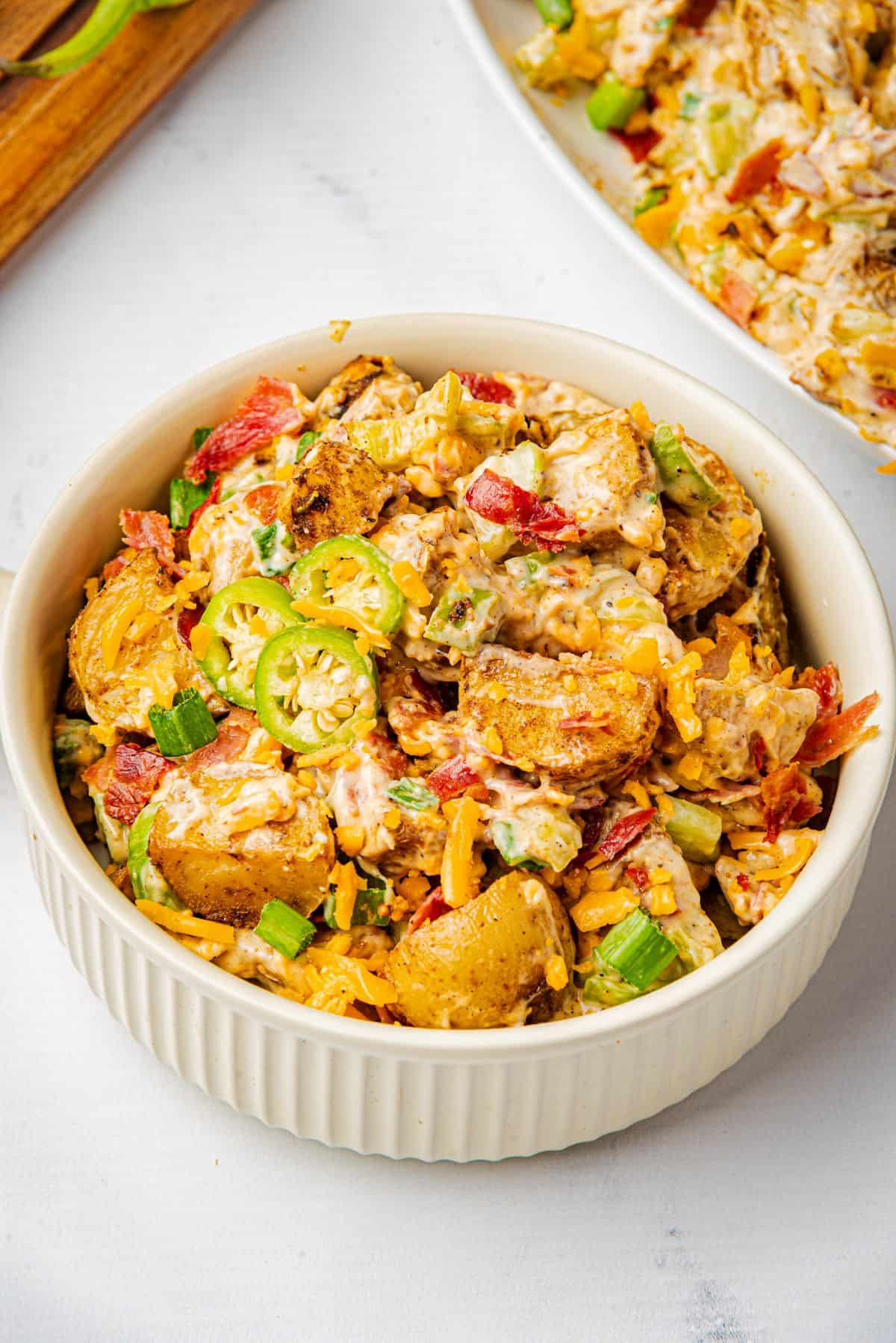 Jalapeno popper potato salad in a white bowl.