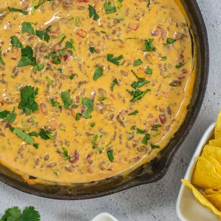 Ground beef queso dip with Rotel and Velveeta cheese in a large skillet.