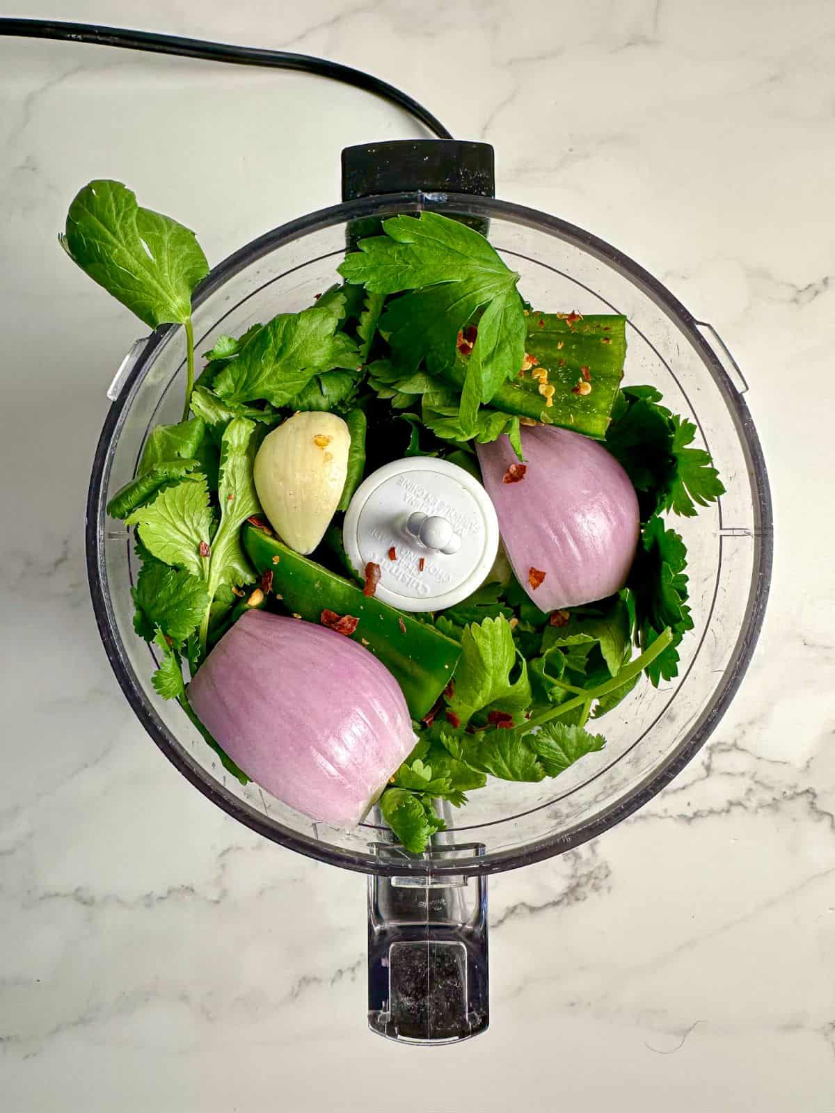 Cilantro, jalapeno, shallots, garlic, parsley, and oregano in a food processor.