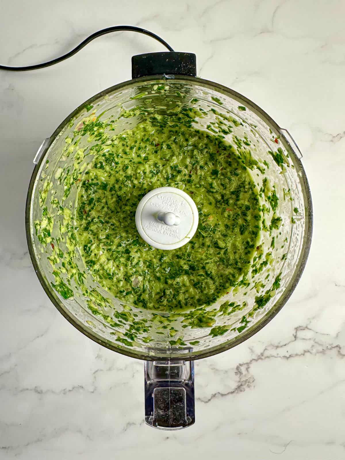 Jalapeno chimichurri ingredients blended in a food processor.