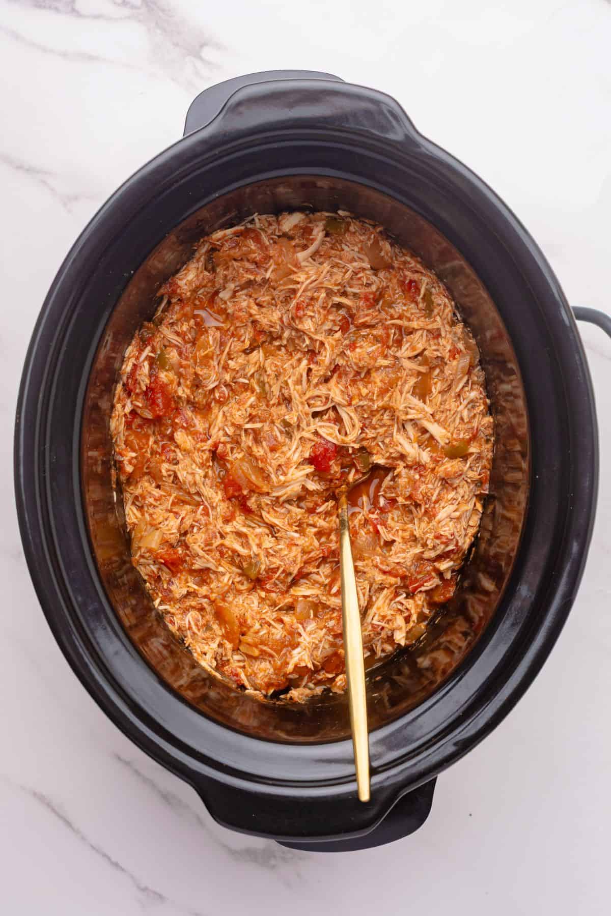 Shredded salsa chicken in a slow cooker.