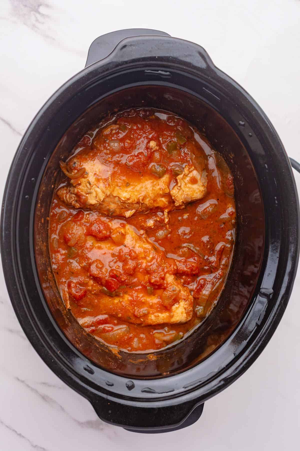Cooked chicken with salsa sauce in a slow cooker.