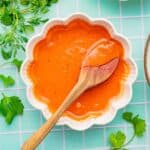 Homemade chipotle crema in a bowl with a wooden spoon.