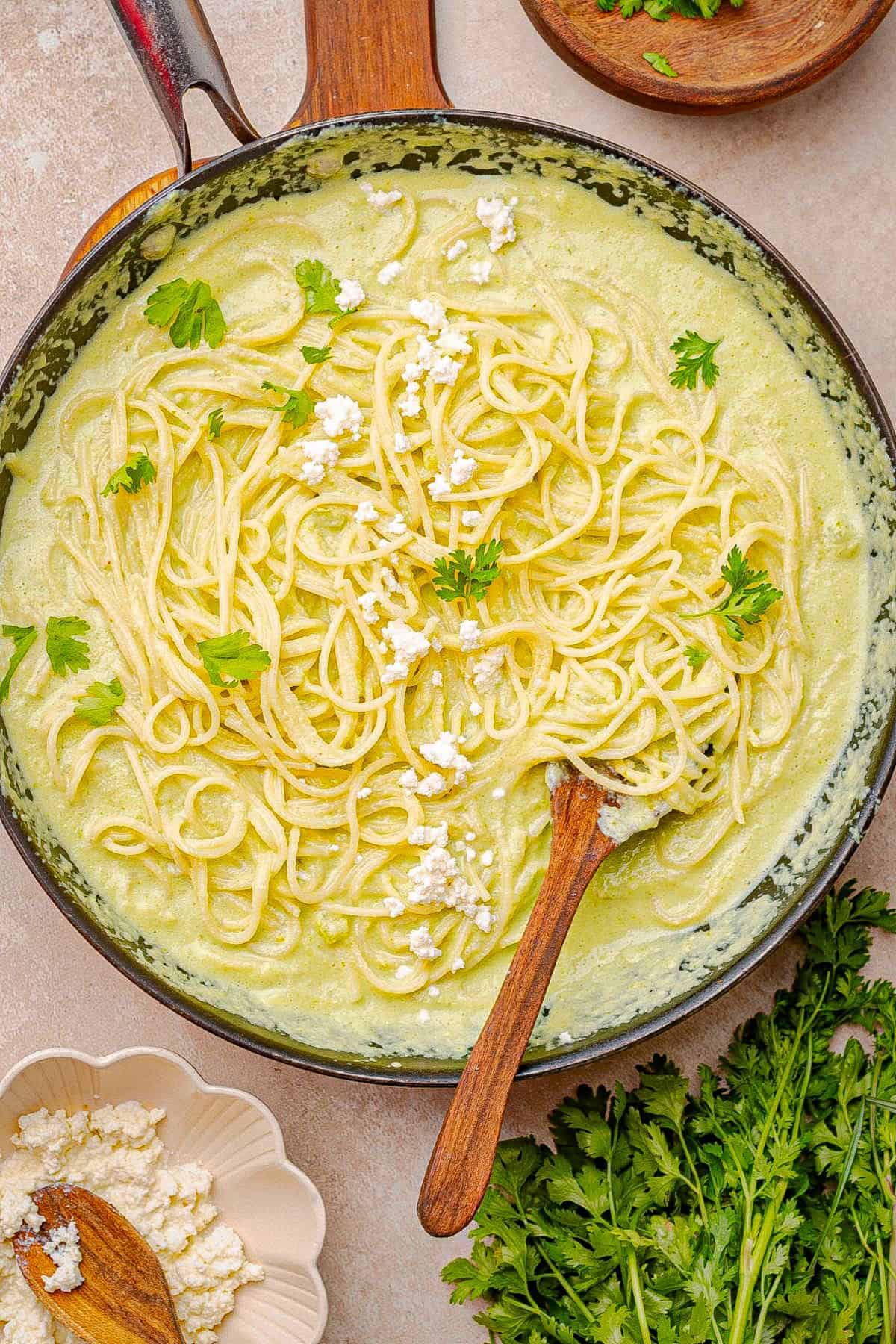 Spaghetti tossed with creamy poblano sauce in a skillet.