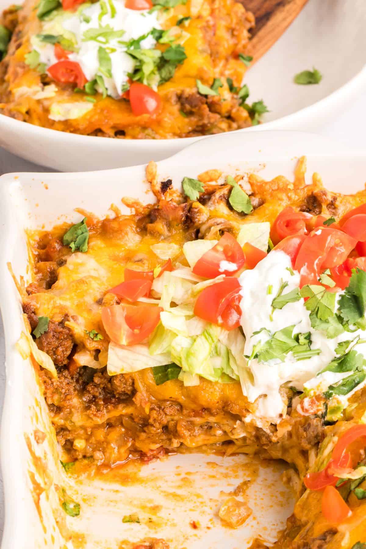 Layers of flour tortillas and beef in this Mexican taco lasagna in a baking dish.