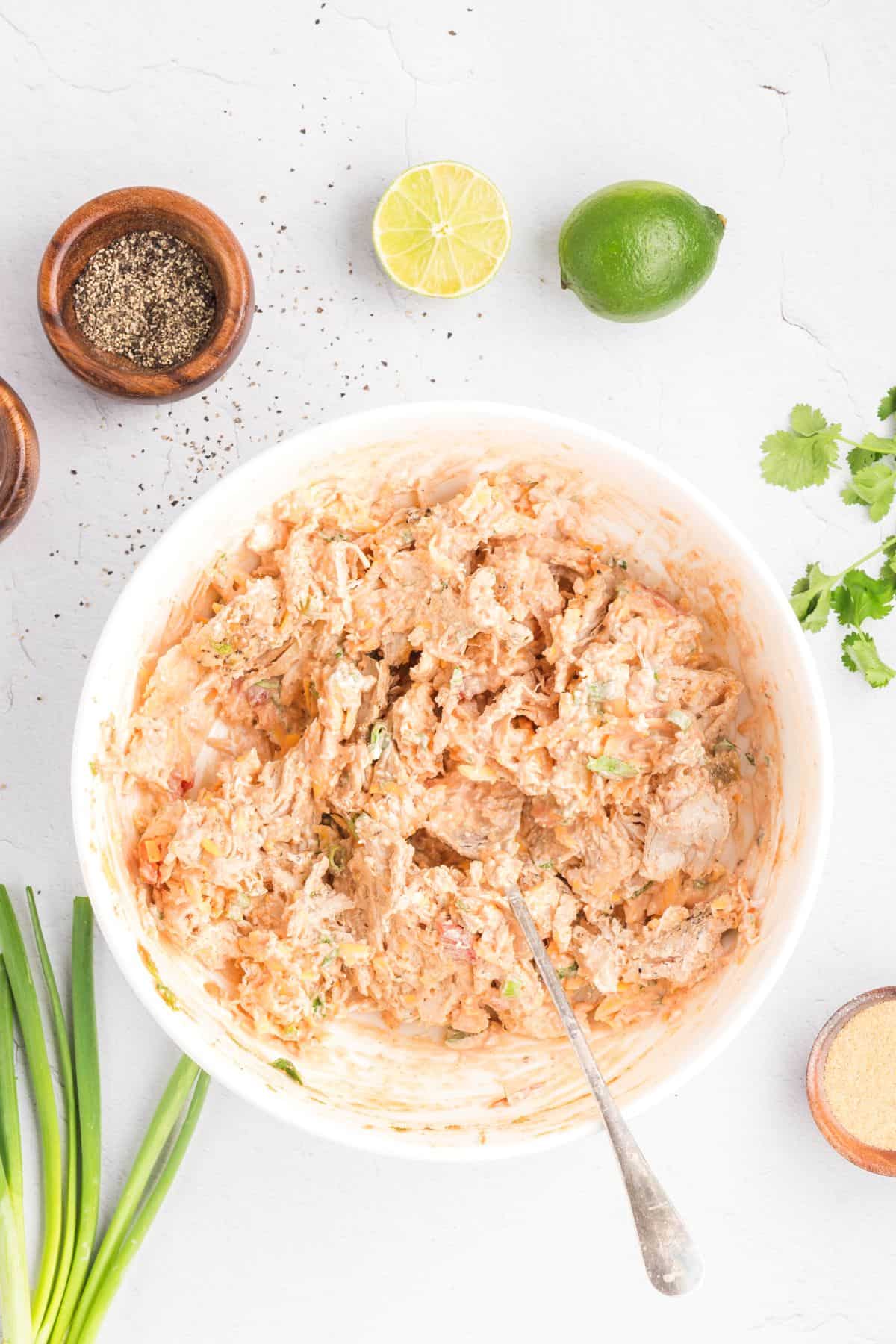 Cream cheese filling for chicken taquitos in a mixing bowl.