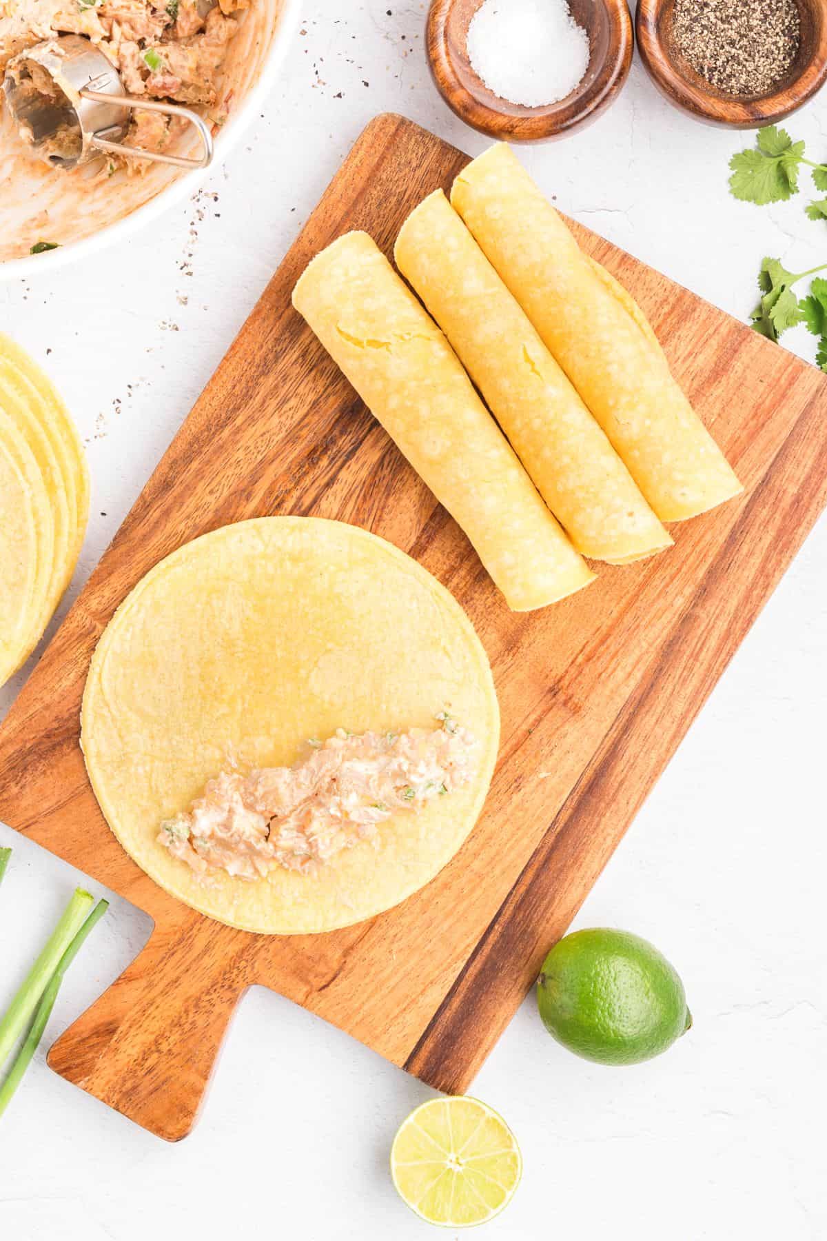 Chicken taquito filling inside of corn tortillas.