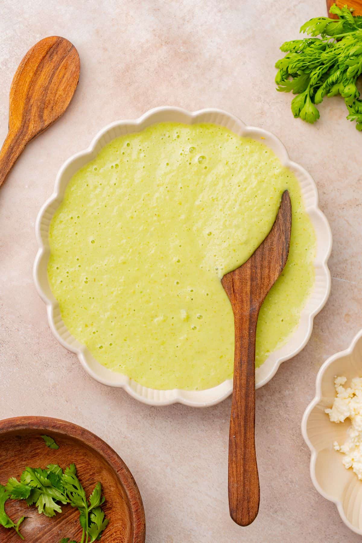 Poblano cream sauce in a bowl with a wooden spoon.