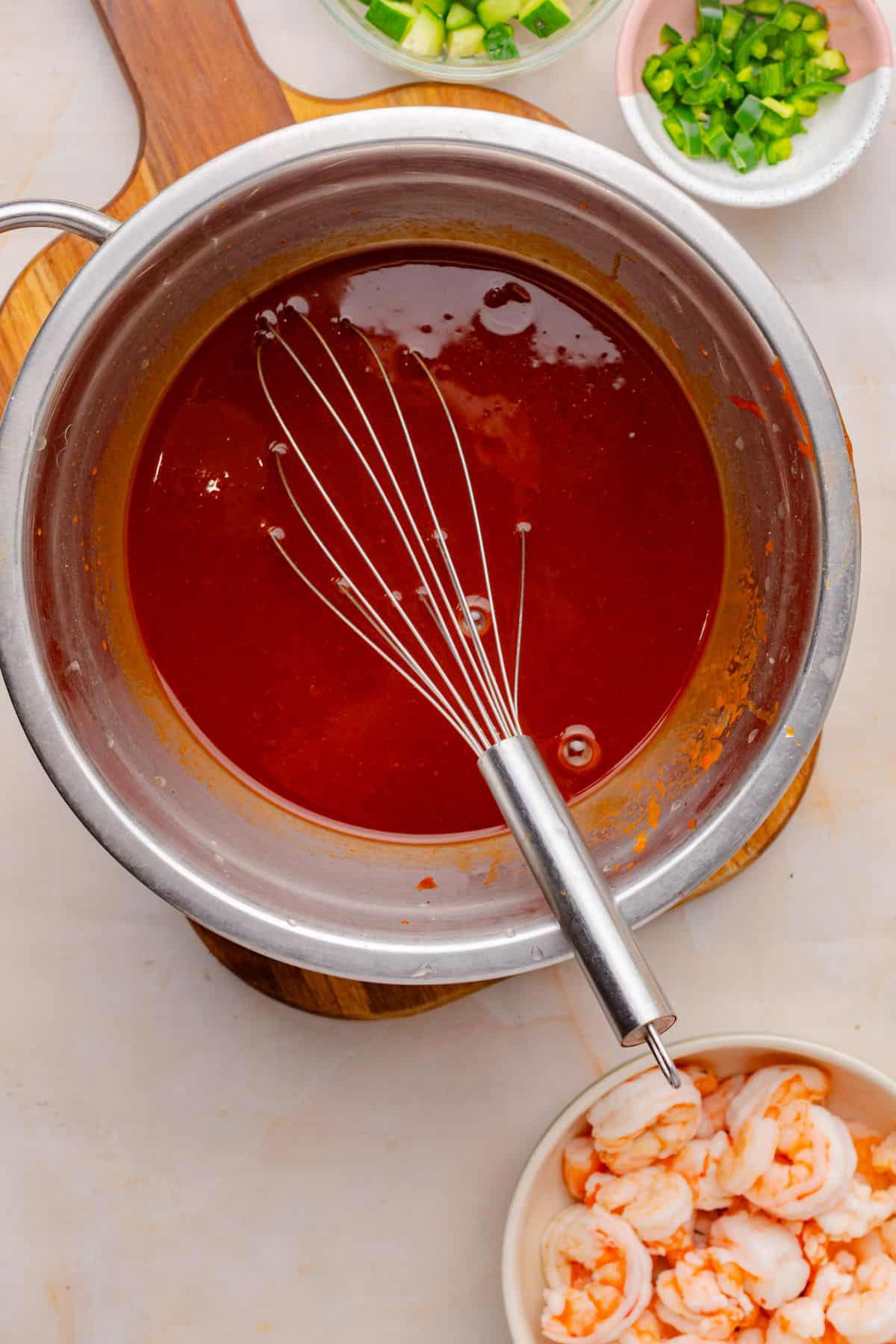 Mexican shrimp cocktail sauce in a mixing bowl with a whisk.