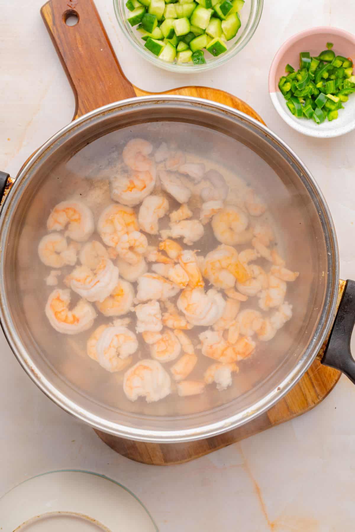 Shrimp poaching in a pot of boiling water.