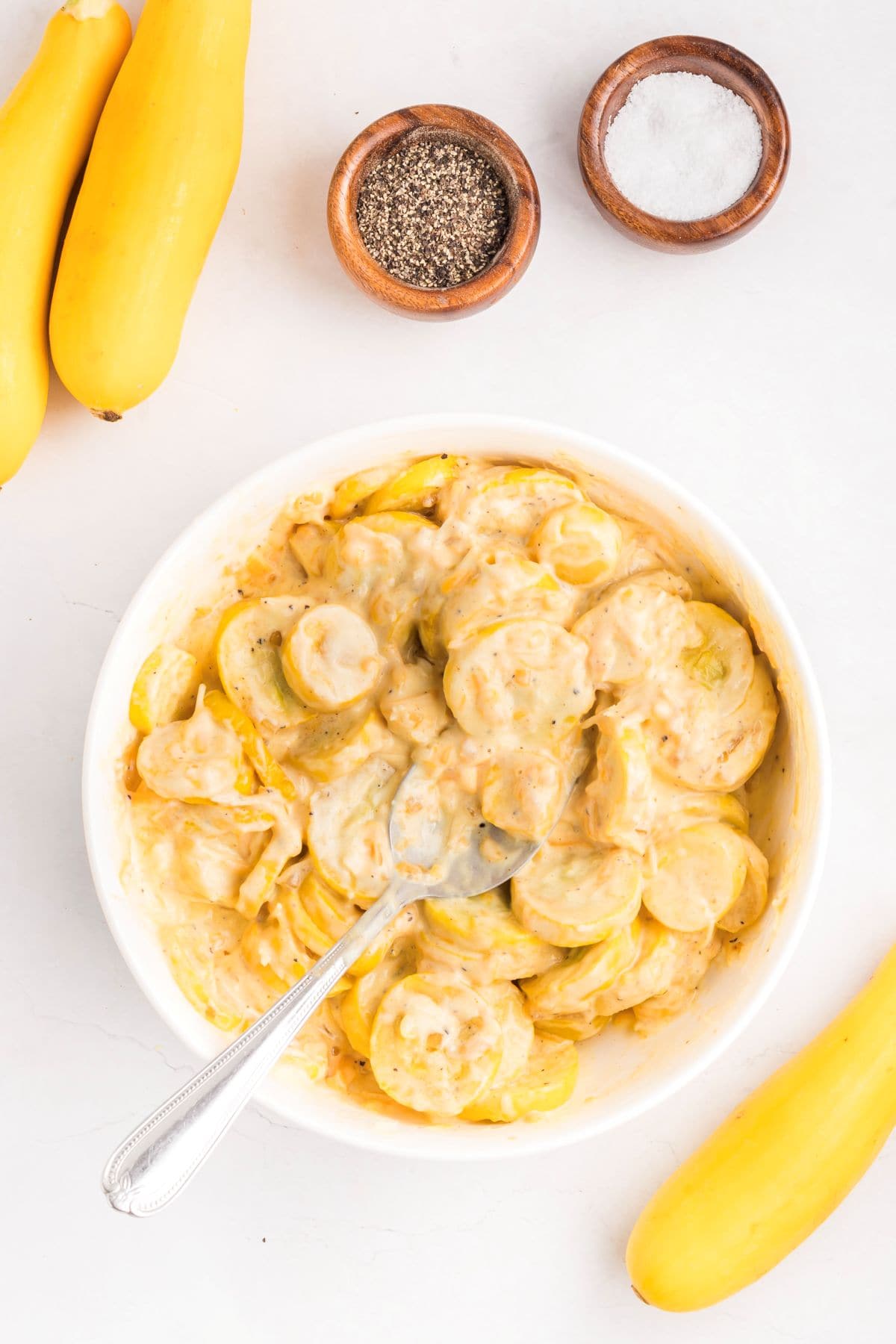 Sliced and cooked yellow squash being adding to the creamy filling.
