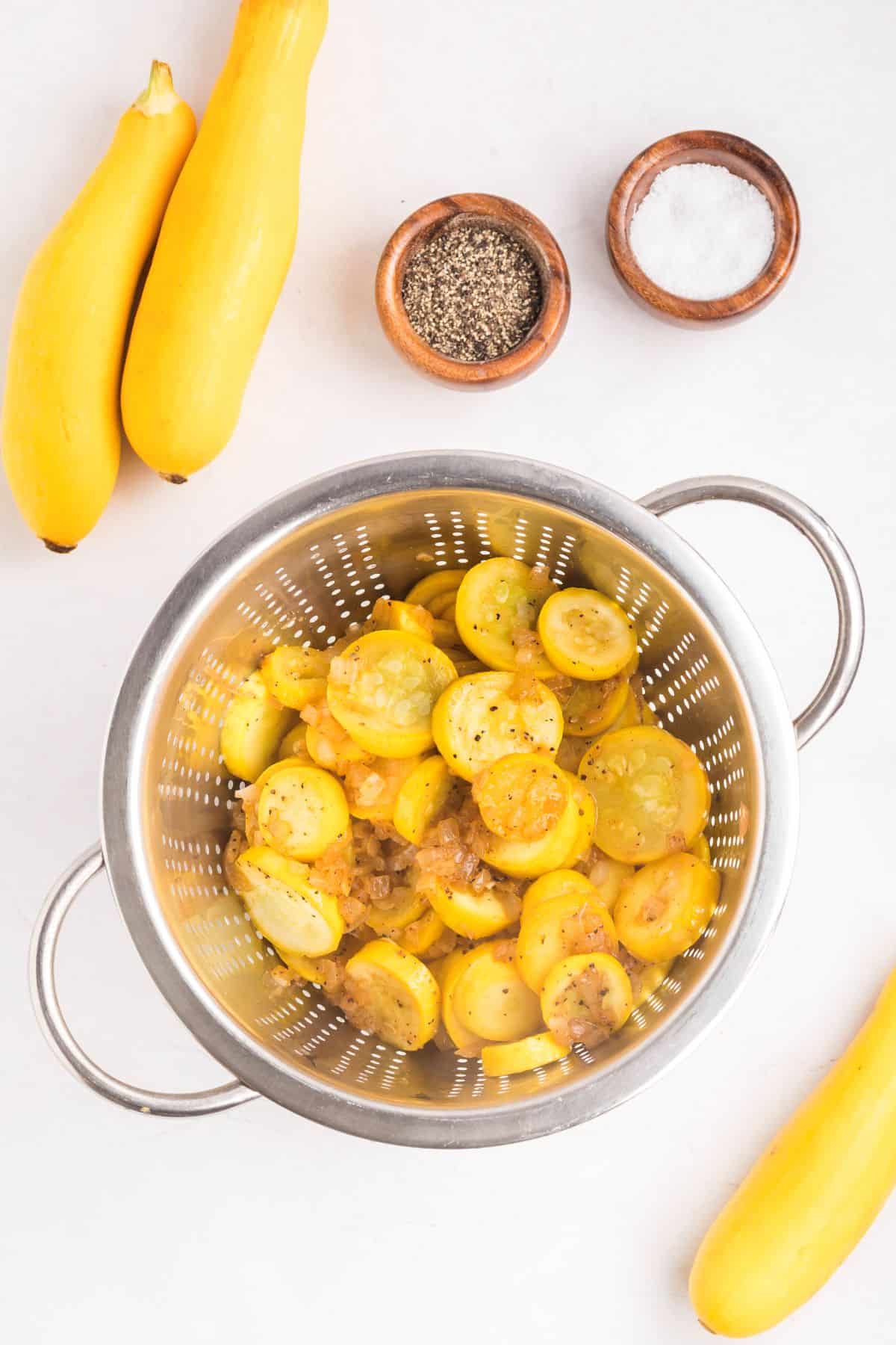 Yellow squash mixture draining in a colander.